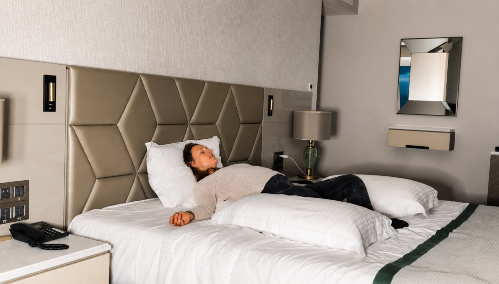 Flugbegleiter praktiziert Yin Yoga auf dem Hotelbett im Layover